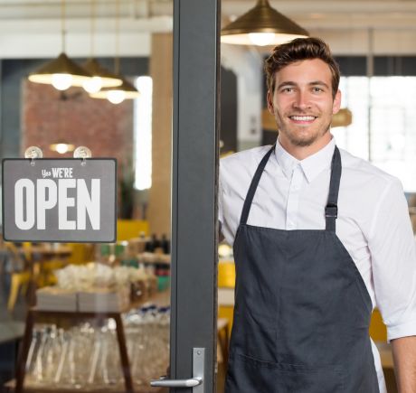 A man standing in the doorway of his business. A man standing in the doorway of his business